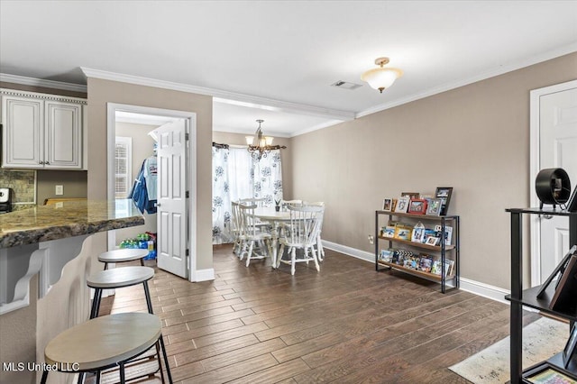 dining area with ornamental molding, visible vents, and dark wood finished floors