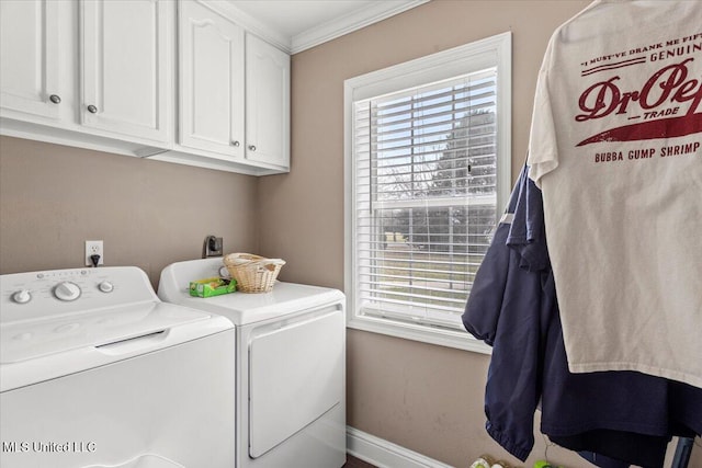 laundry area featuring ornamental molding, washing machine and dryer, cabinet space, and baseboards