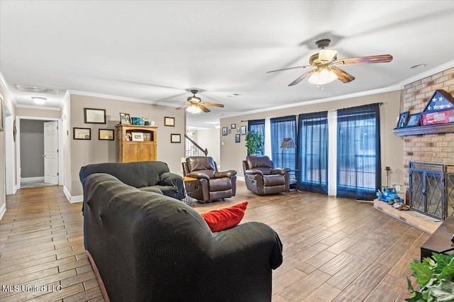 living room with a fireplace, crown molding, visible vents, light wood-style flooring, and baseboards