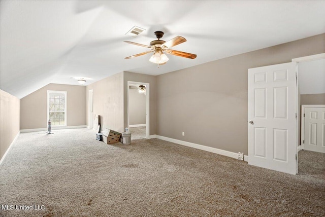 additional living space featuring carpet, visible vents, vaulted ceiling, and baseboards