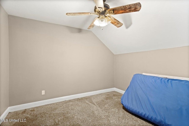 unfurnished bedroom featuring lofted ceiling, ceiling fan, carpet, and baseboards