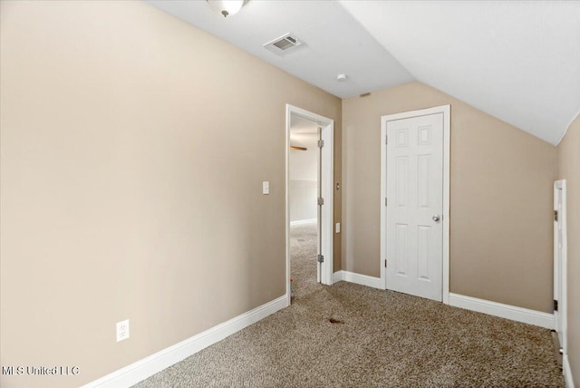 unfurnished bedroom featuring lofted ceiling, carpet floors, visible vents, and baseboards