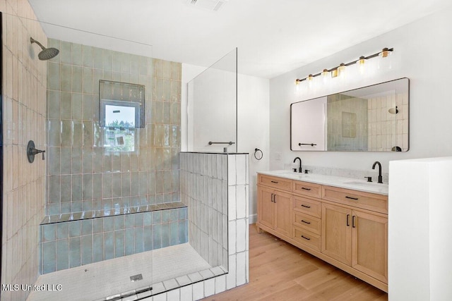 bathroom featuring tiled shower, vanity, and hardwood / wood-style flooring