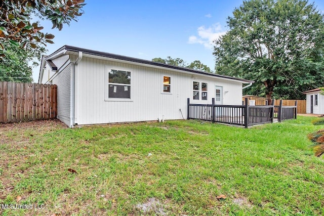 rear view of house with a deck and a lawn