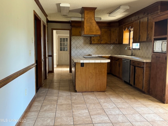 kitchen featuring tasteful backsplash, tile countertops, dishwasher, sink, and a center island