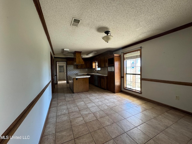 kitchen with crown molding, a textured ceiling, light tile patterned flooring, and backsplash