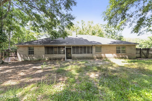 1317 Rosemont Dr, Gautier, MS 39553 - back of house featuring brick siding, fence, a chimney, and a sunroom