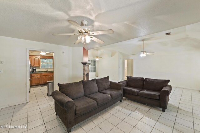1317 Rosemont Dr, Gautier, MS 39553 - living room featuring light tile patterned floors, a ceiling fan, a textured ceiling, and baseboards
