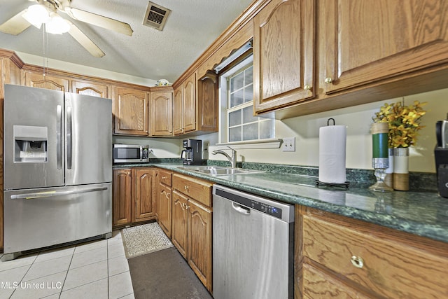 1317 Rosemont Dr, Gautier, MS 39553 - kitchen featuring stainless steel appliances, a sink, ceiling fan, light tile patterned flooring, and brown cabinetry