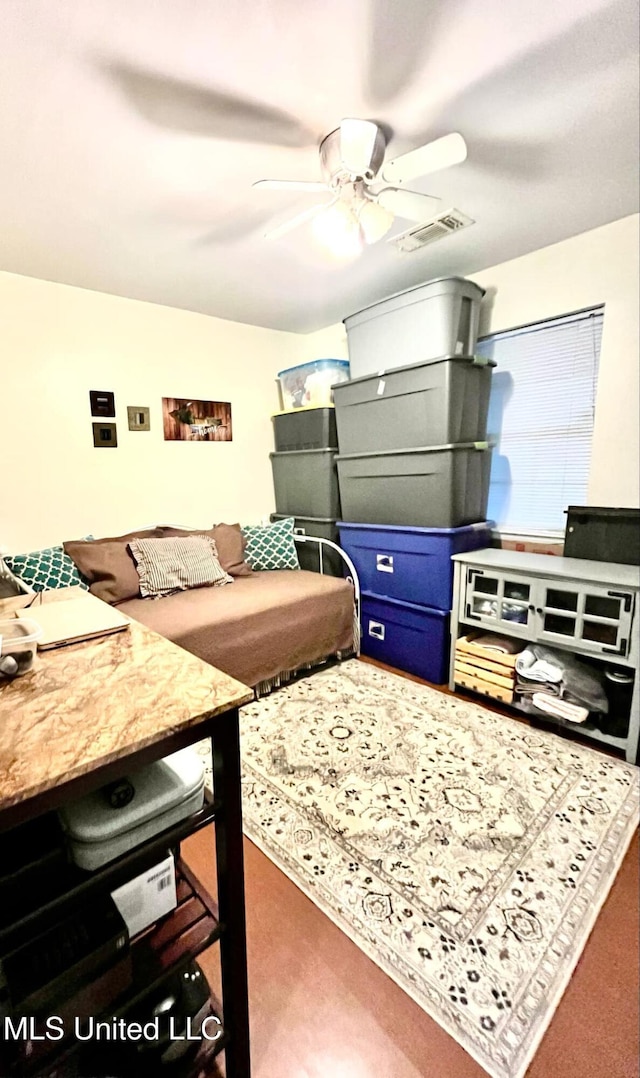 living area featuring visible vents and a ceiling fan