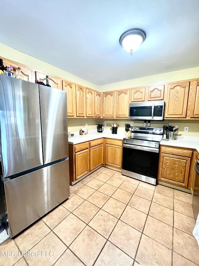 kitchen featuring light tile patterned floors, light countertops, appliances with stainless steel finishes, and light brown cabinets