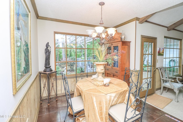 697 Country Place Dr, Pearl, MS 39208 - dining area featuring a chandelier, healthy amount of natural light, a textured ceiling, crown molding, and a wainscoted wall