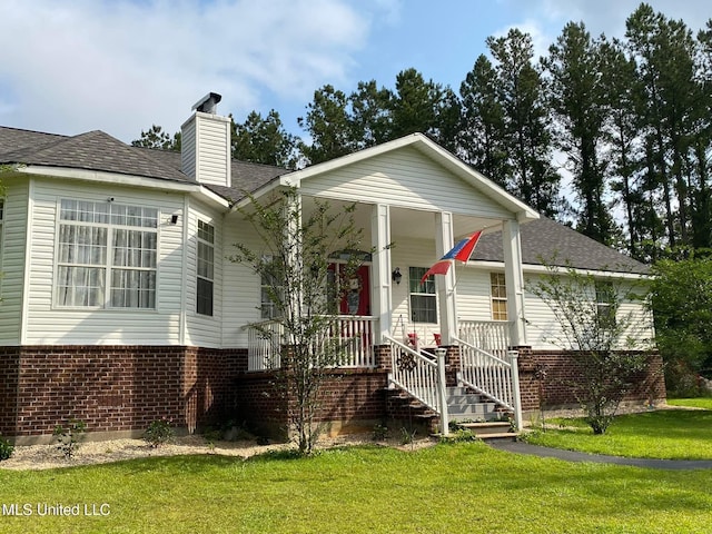 20507 Old Biloxi Rd, Vancleave, MS 39565 - view of front of house with brick siding, a front yard, a chimney, and covered porch