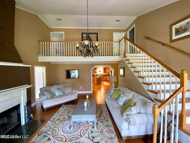 20507 Old Biloxi Rd, Vancleave, MS 39565 - living room with high vaulted ceiling, wood finished floors, stairway, a chandelier, and arched walkways