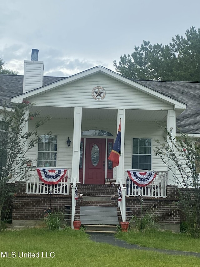 20507 Old Biloxi Rd, Vancleave, MS 39565 - view of front of house with covered porch, roof with shingles, and a chimney