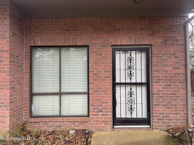 doorway to property with brick siding