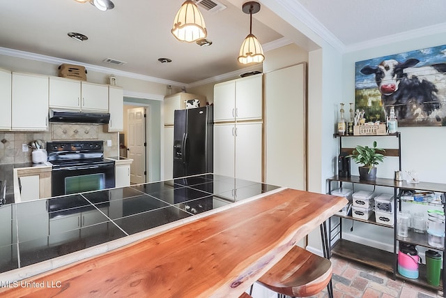 kitchen featuring hanging light fixtures, tile countertops, decorative backsplash, white cabinets, and black appliances