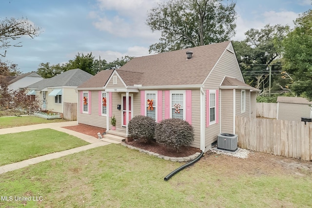 view of front of property with central AC and a front lawn