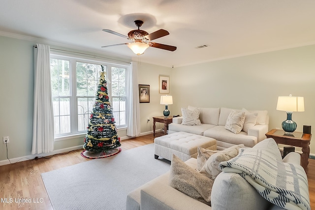 living room with light hardwood / wood-style flooring, ceiling fan, and crown molding