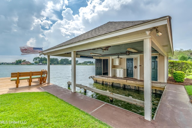 view of dock with a water view and a lawn