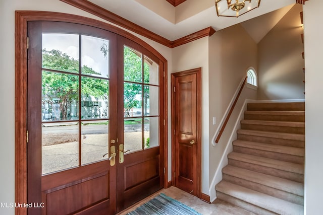 tiled foyer with french doors and crown molding