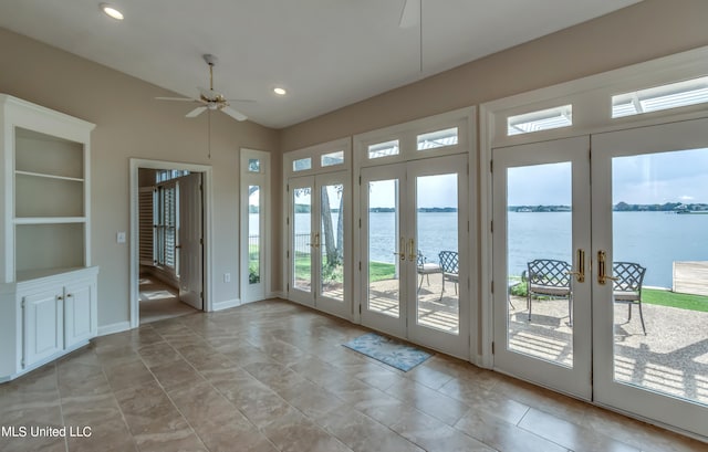 entryway with built in features, french doors, a water view, and ceiling fan