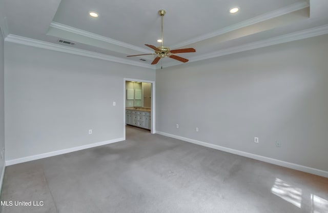 carpeted spare room featuring ceiling fan, a raised ceiling, and ornamental molding