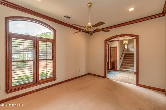 carpeted spare room with ornamental molding and ceiling fan