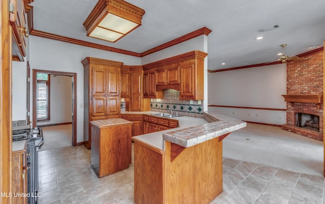 kitchen featuring sink, a fireplace, a kitchen island, kitchen peninsula, and light colored carpet