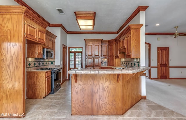 kitchen with kitchen peninsula, electric range, a breakfast bar, tile counters, and light colored carpet