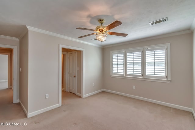 carpeted spare room featuring ceiling fan and ornamental molding