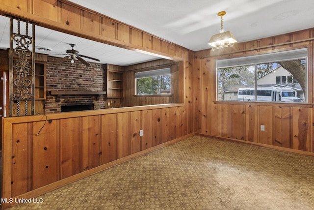 bar featuring ceiling fan, decorative light fixtures, and wood walls