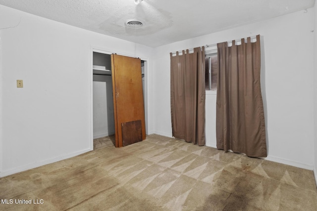 unfurnished bedroom featuring a closet, carpet flooring, and a textured ceiling