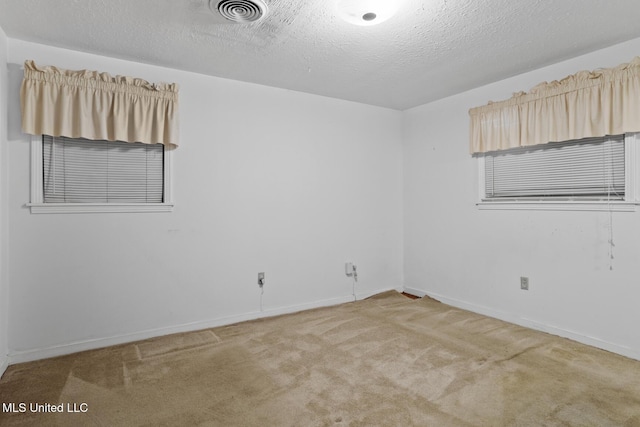 carpeted spare room featuring a textured ceiling