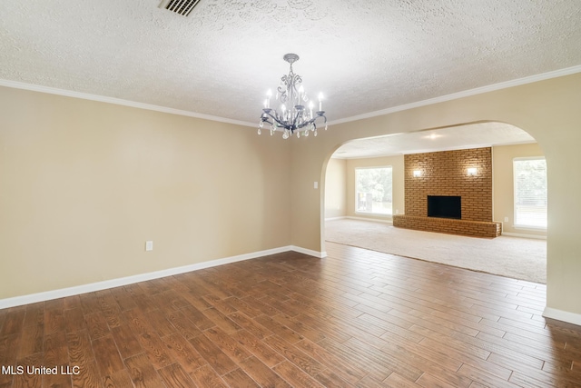 12 Bayou View Dr, Gulfport, MS 39507 - unfurnished living room with arched walkways, wood finished floors, a textured ceiling, a chandelier, and a fireplace