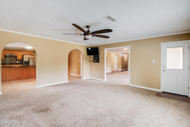 12 Bayou View Dr, Gulfport, MS 39507 - unfurnished living room featuring arched walkways, a ceiling fan, light colored carpet, crown molding, and a textured ceiling