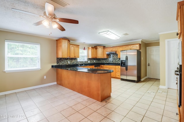 12 Bayou View Dr, Gulfport, MS 39507 - kitchen with stainless steel refrigerator with ice dispenser, a peninsula, ornamental molding, tasteful backsplash, and dark countertops