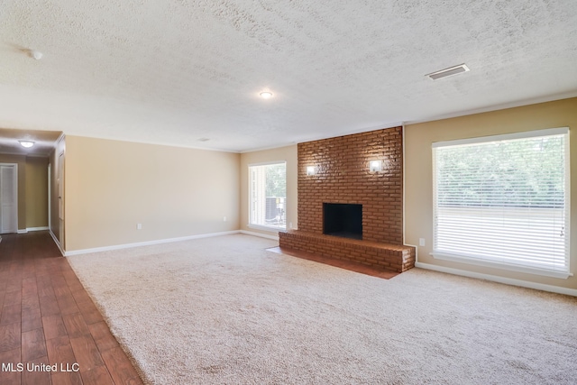 12 Bayou View Dr, Gulfport, MS 39507 - unfurnished living room with a textured ceiling, wood finished floors, and a brick fireplace