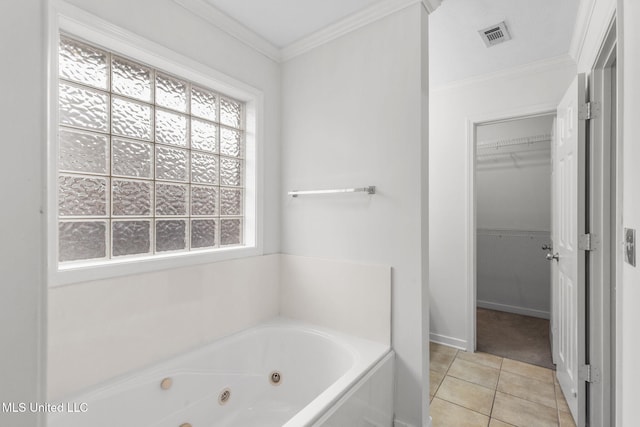 bathroom with visible vents, a tub with jets, tile patterned flooring, a walk in closet, and crown molding