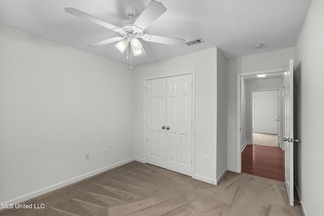 unfurnished bedroom with carpet floors, a closet, visible vents, and baseboards