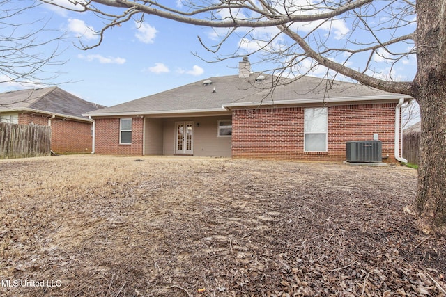 rear view of property featuring central air condition unit, fence, french doors, and brick siding