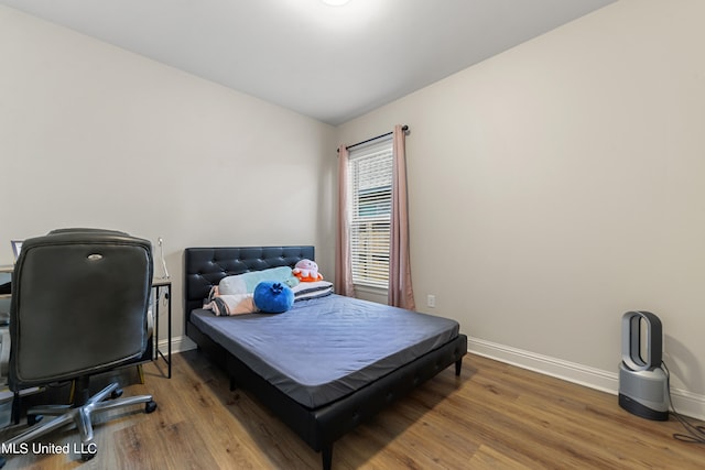 bedroom featuring vaulted ceiling and wood-type flooring