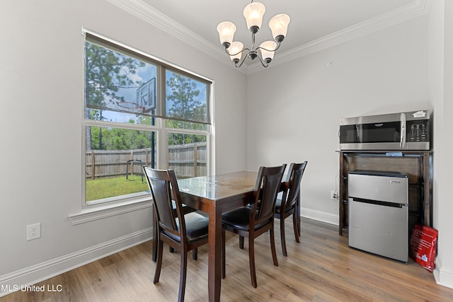 dining room with ornamental molding, a chandelier, and light wood-type flooring