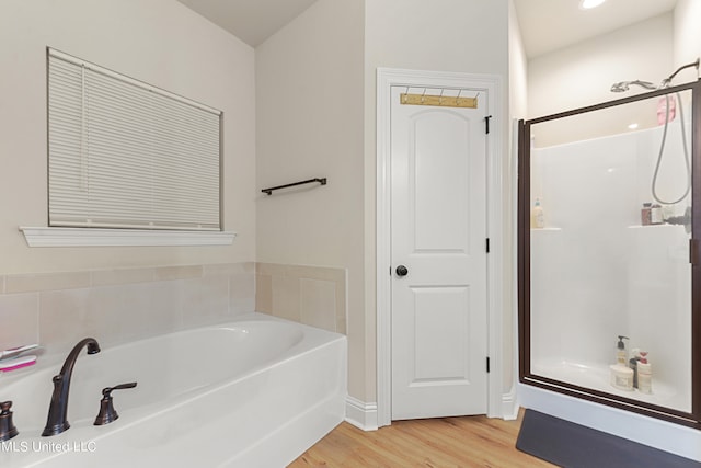 bathroom with wood-type flooring and separate shower and tub