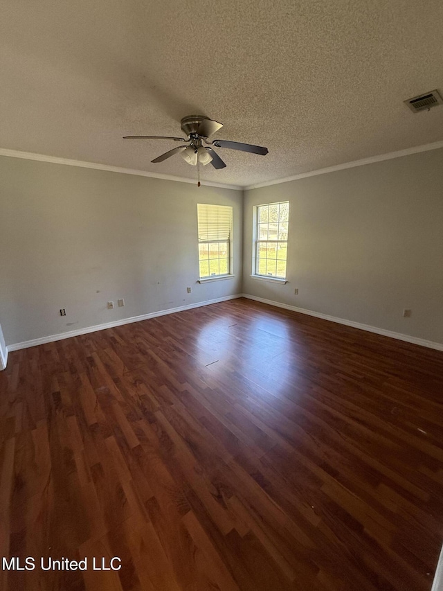 empty room with a textured ceiling, dark hardwood / wood-style floors, ceiling fan, and ornamental molding