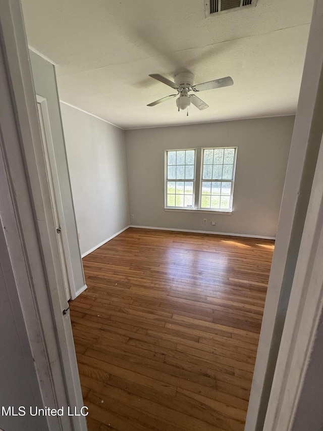 empty room featuring ceiling fan and dark hardwood / wood-style floors