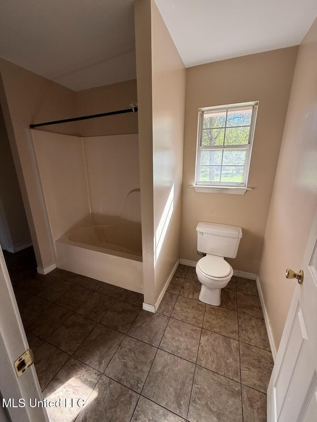 bathroom with tile patterned flooring, toilet, and a shower