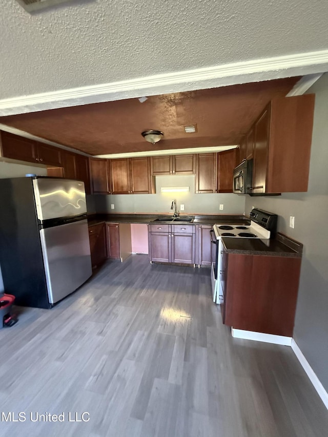 kitchen with sink, dark hardwood / wood-style flooring, a textured ceiling, and appliances with stainless steel finishes