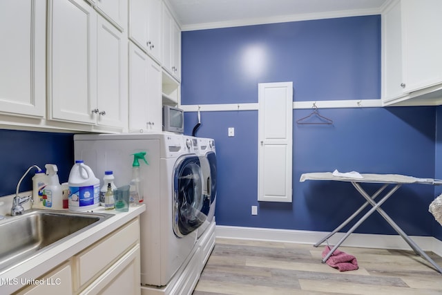 41 C G Evans Rd, Wiggins, MS 39577 - laundry area with a sink, light wood-type flooring, baseboards, separate washer and dryer, and cabinet space