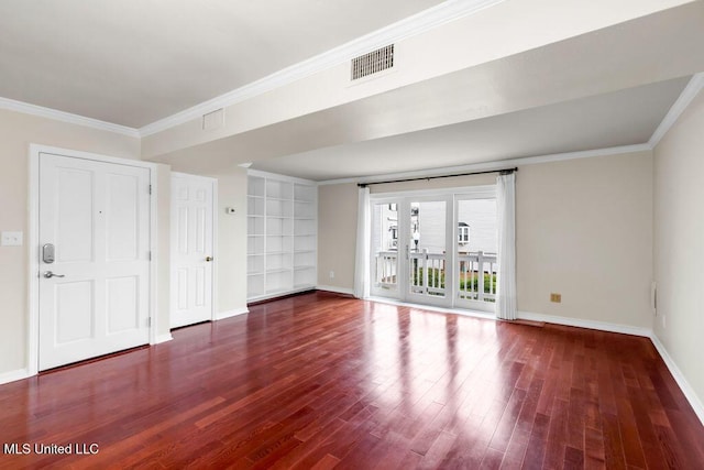 unfurnished room featuring baseboards, wood finished floors, and crown molding